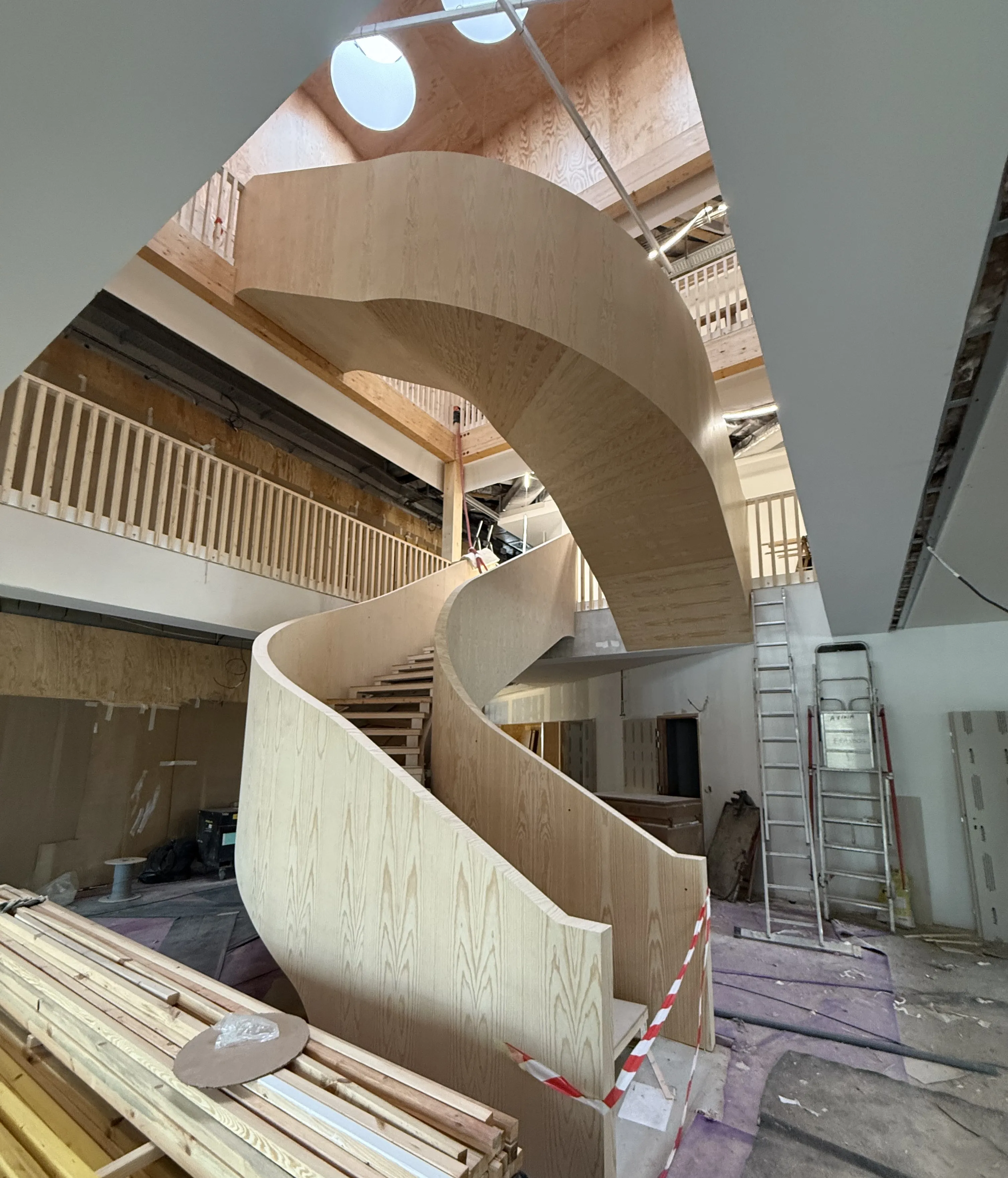 Vu d'un magnifique escalier quart tournant en bois tout en arrondi.